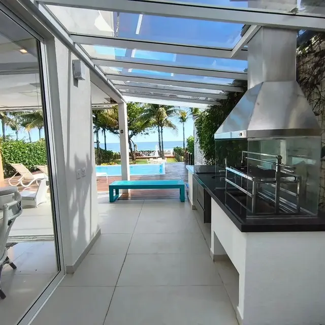 Área gourmet coberta com churrasqueira e vista para a piscina
